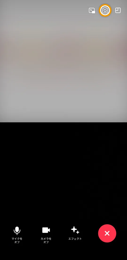iPhoneのビデオ通話画面。右上に並ぶアイコンのうち、中央のカメラ切り替えボタンを枠で示しています。
